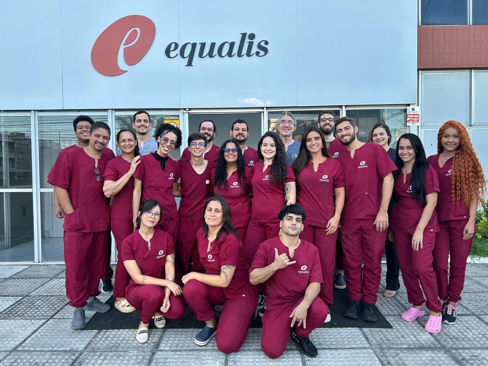 Equipe veterinária do Equalis em frente ao centro de ensino, com uniformes na cor vinho